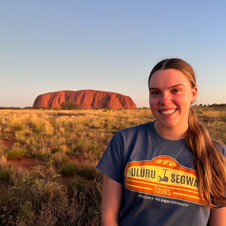 Uluru Segway Tours Guide Hayley poses next to Uluru.
